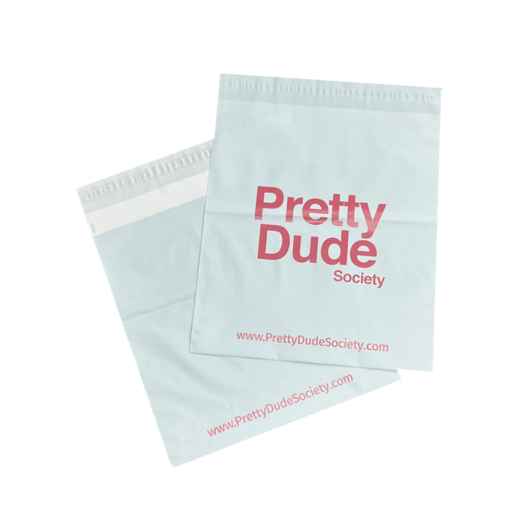 "Sachets d'expédition gris avec le logo 'Pretty Dude Society' et l'adresse web pour une marque élégante."